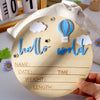 A wooden birth announcement sign featuring blue clouds, a hot air balloon, and lines for name, date, time, weight, and length