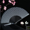 A black and white fan with a traditional Japanese pattern is shown against a dark background.