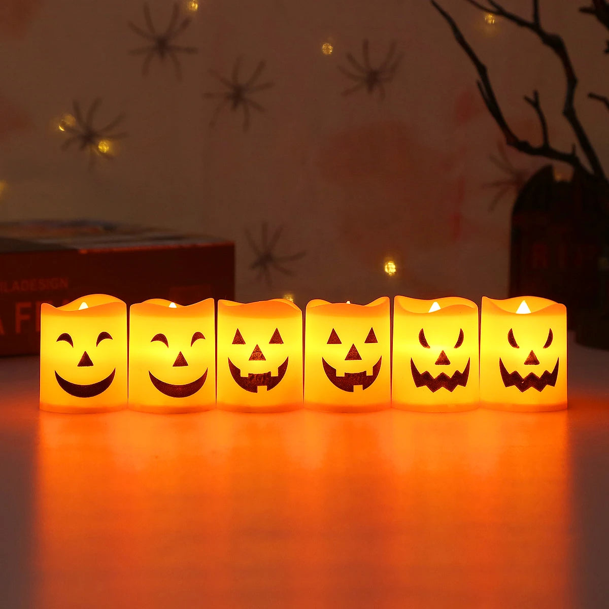A set of six battery-powered LED Halloween candles with carved jack-o'-lantern faces glowing brightly.
