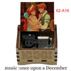 A hand-cranked wooden music box featuring two animated characters, one with red hair and the other with auburn hair.