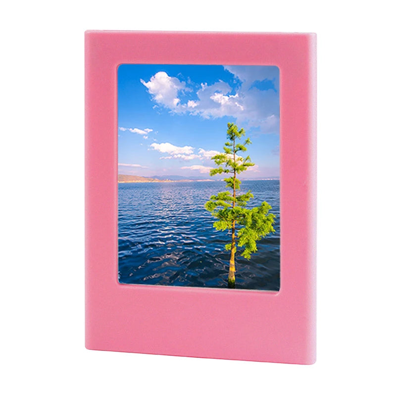 A pink magnetic double-sided frame displaying a scenic view of water and a green tree under a blue sky.