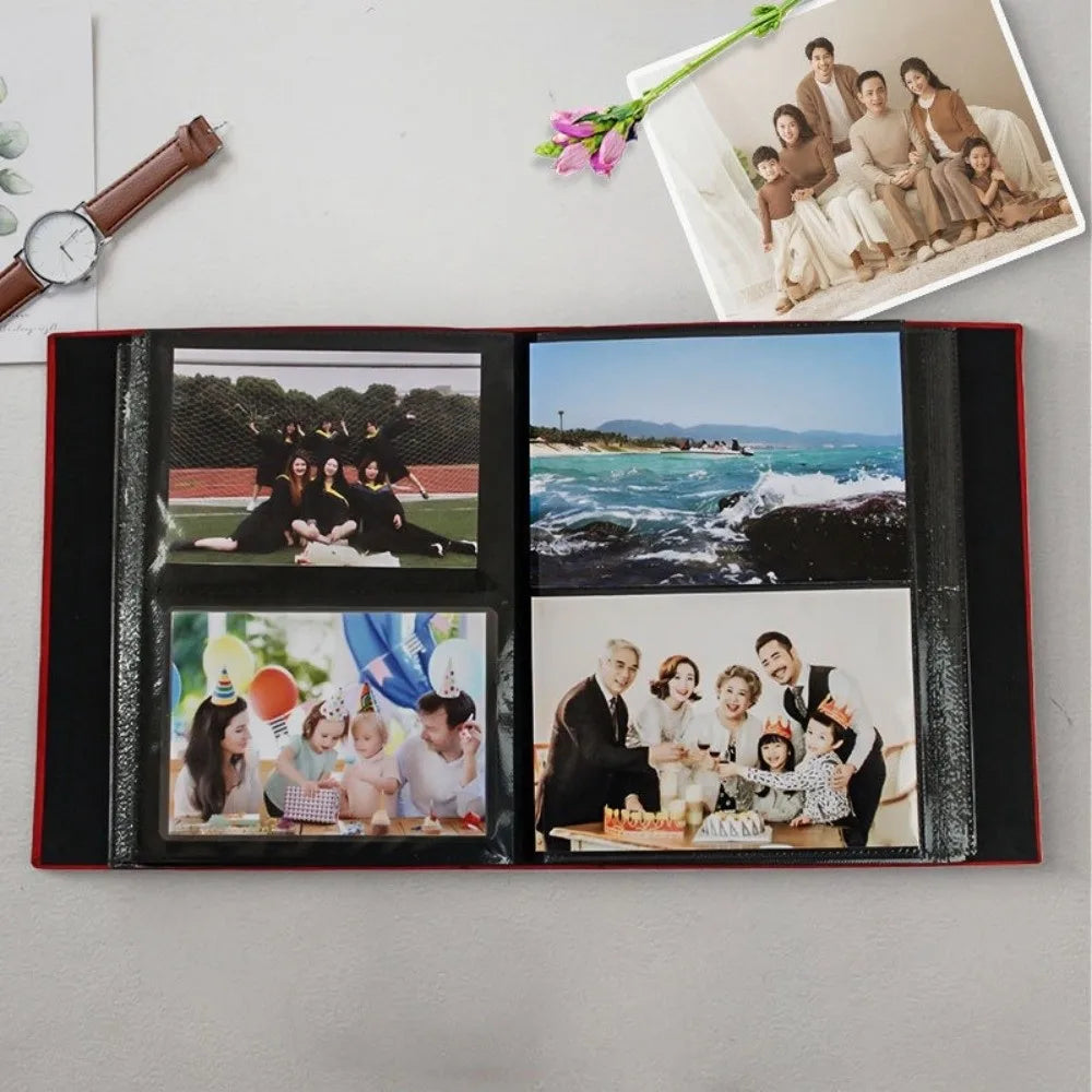 A black linen-cover photo album displaying several family and landscape photographs.