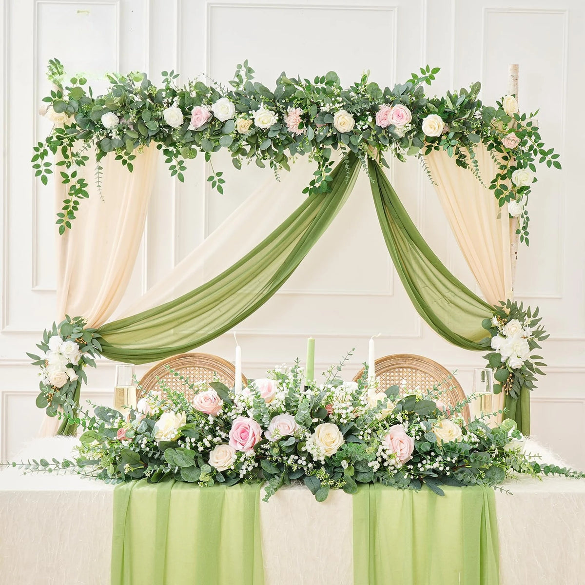 Arco floral decorado con follaje y rosas, cubierto en tela verde salvia suave.