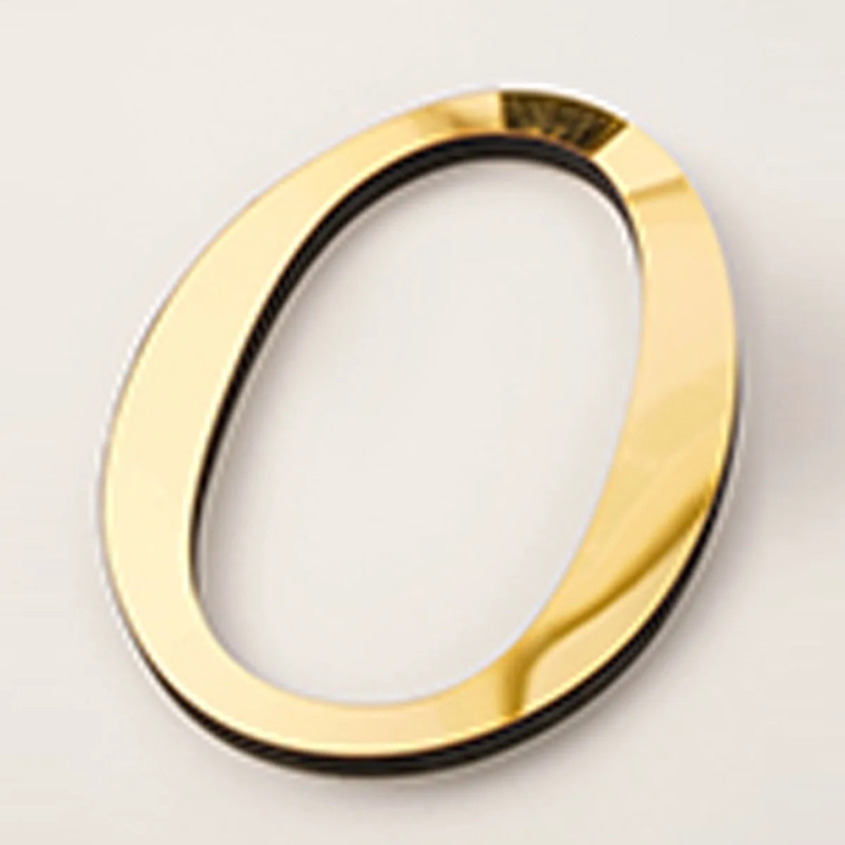A gold acrylic mirror letter O shape wall sticker for decorative purposes.