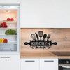 Rustic farmhouse metal wall sign featuring kitchen utensils on a wooden backsplash.