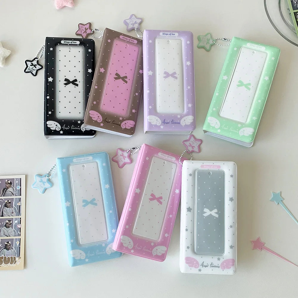 A collection of pink, purple, and green photo booth albums with star-shaped charms arranged on a white surface.