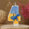 A birthday candle shaped like the number 4 featuring a blue dinosaur on an orange background.