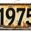 Letrero de aluminio vintage con el año 1975 grabado en una superficie envejecida.