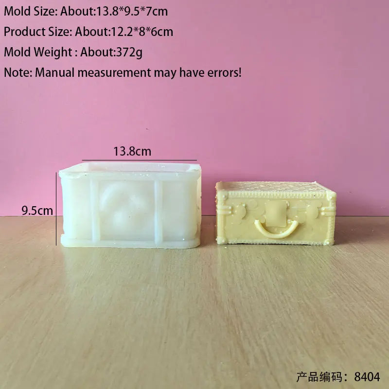 A white silicone mold shaped like a rectangular handbag is shown next to a finished yellow candle product.
