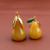 Gold-toned pear-shaped fruit keychain charm with a green gemstone detail.