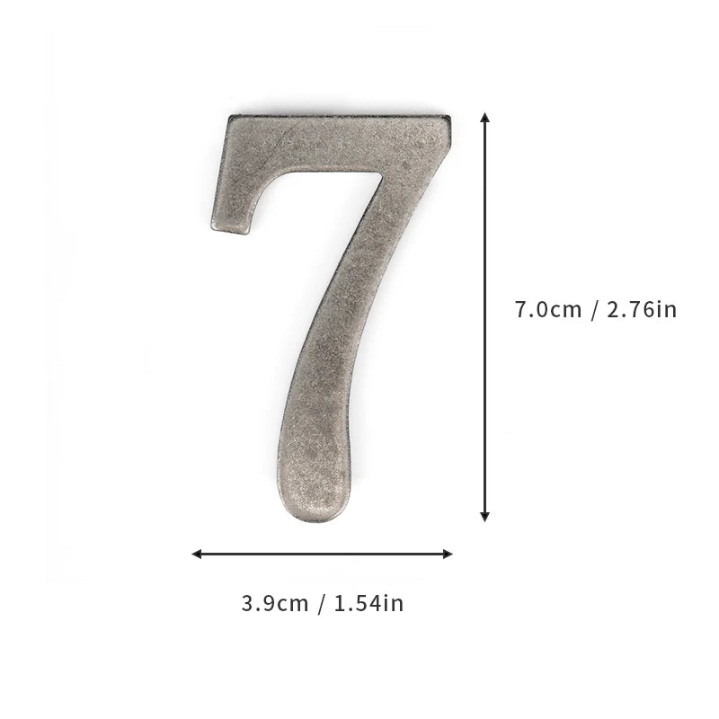 A silver magnetic house number shaped like the numeral seven, measuring 7.0cm or 2.76in.