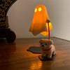 A 3D printed desk figurine of a glowing orange ghost with a small dog sitting beneath it.