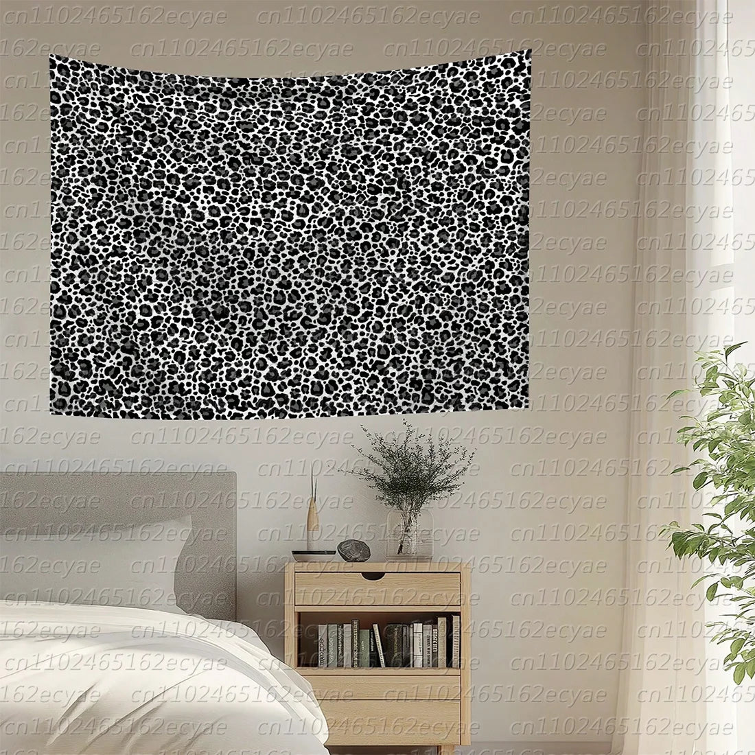 A black and white leopard print decorative wall tapestry hanging on a light-colored wall.