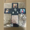 A handcrafted pocket shrine featuring a cross with religious imagery and text.