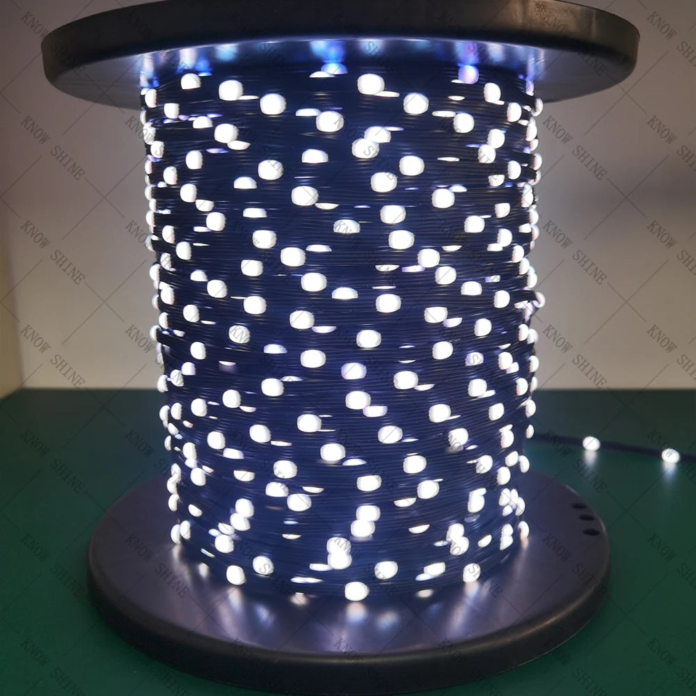 A close-up view of a cylindrical string of blue LED lights with white dots, mounted on a dark base.