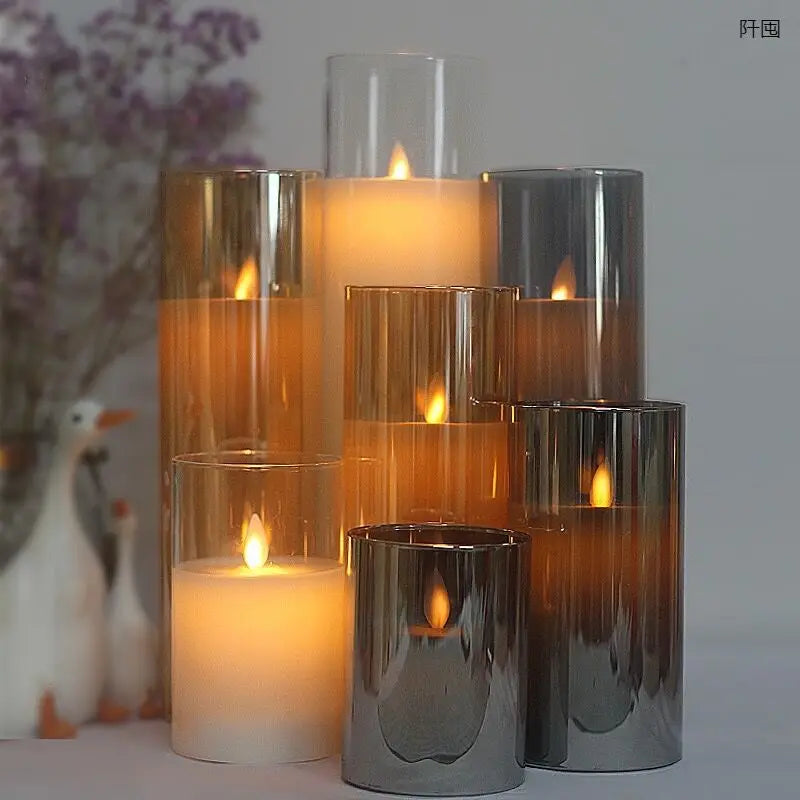 A set of pillar candles in glass holders with a remote and timer, illuminated by a warm glow.