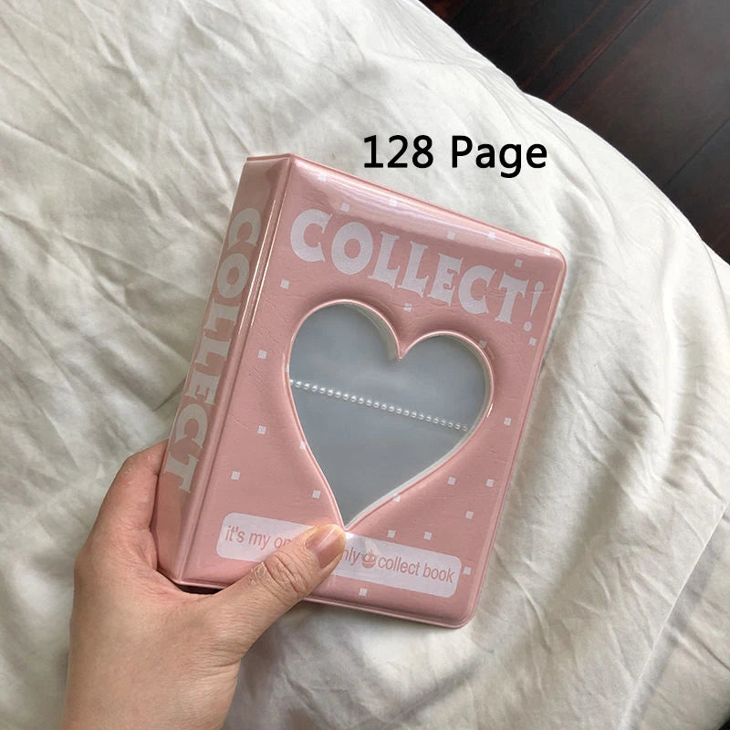 A pink photo album titled Collect with a heart design resting on white bedding.