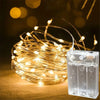 A bundle of warm yellow fairy string lights is displayed next to their battery pack.