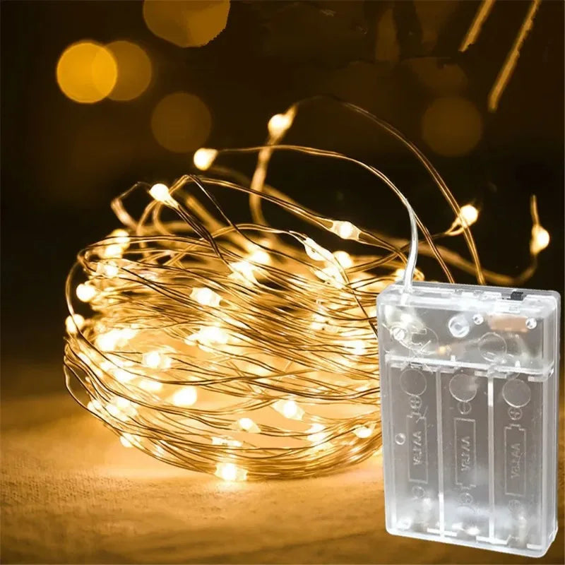 A bundle of warm yellow fairy string lights is displayed next to their battery pack.