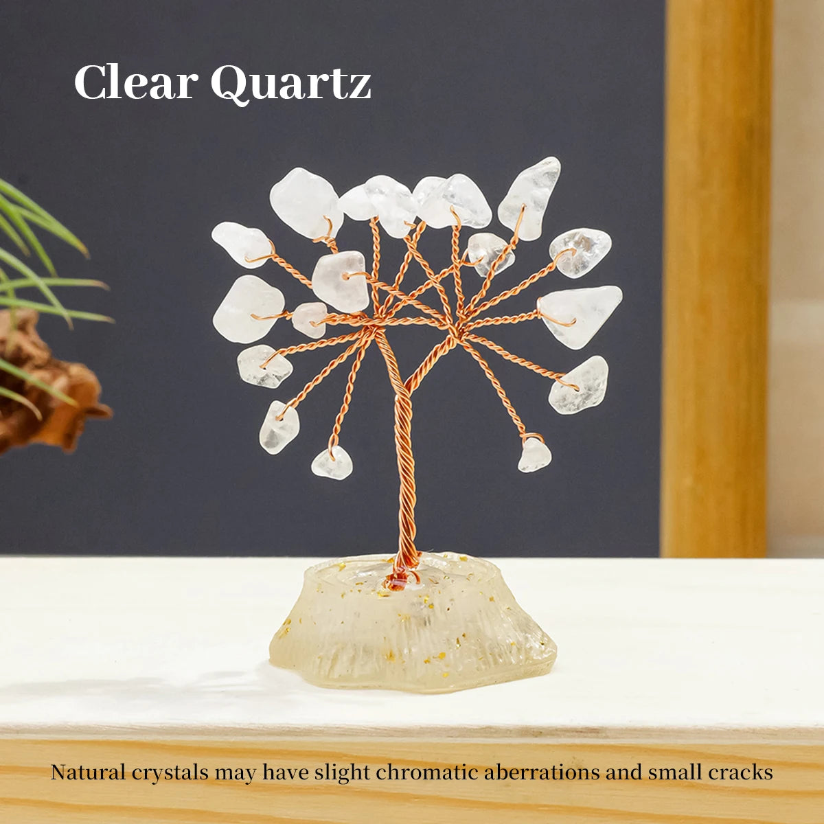 A clear quartz crystal tree made of natural stones growing from a base on a white surface.