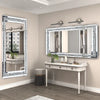 A rectangular silver crystal rhinestone wall mirror with a sparkling frame mounted above a white vanity table.