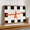 A framed wall art print featuring an orange stick figure saying I love you this much on a black and white checkered backgroun