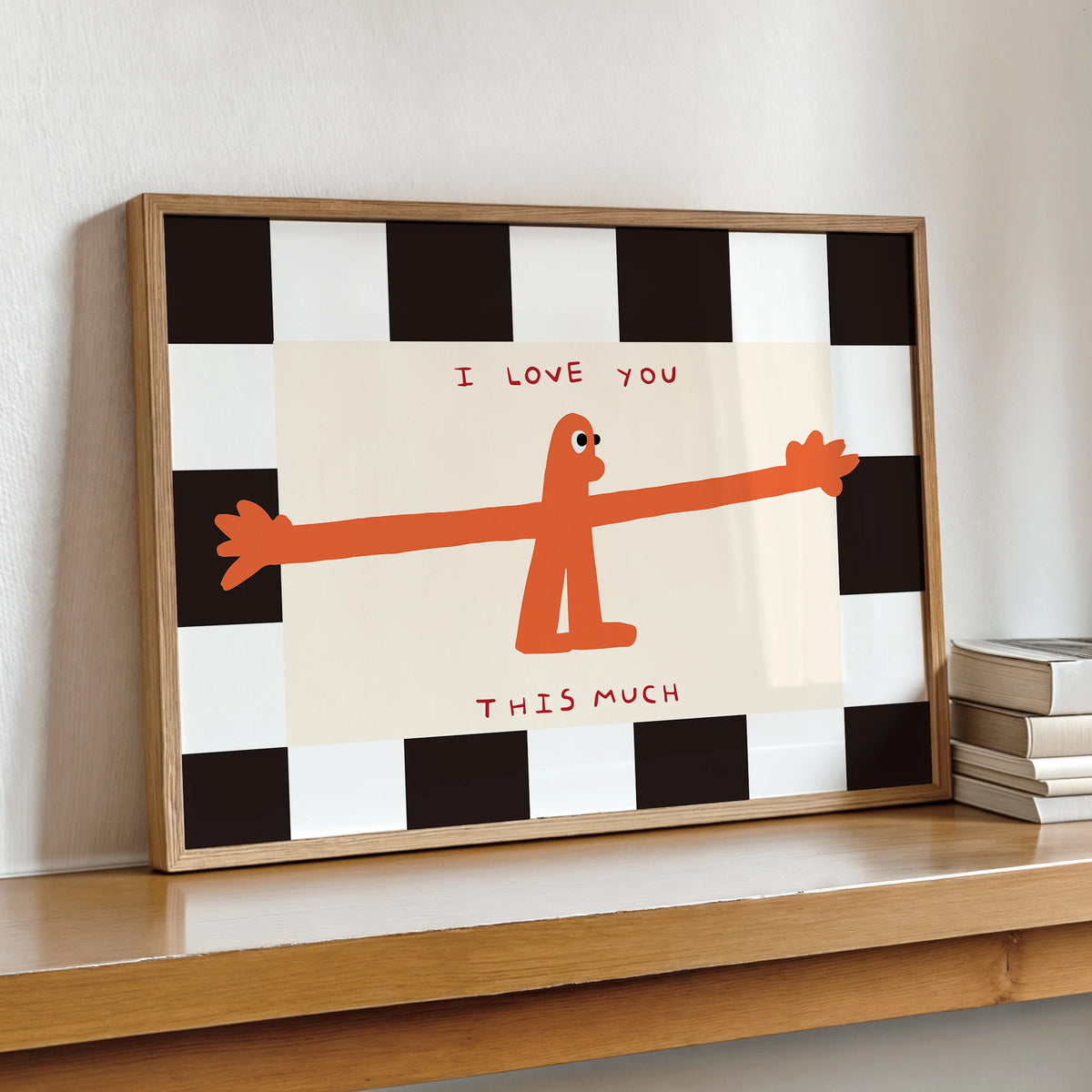 A framed wall art print featuring an orange stick figure saying I love you this much on a black and white checkered backgroun