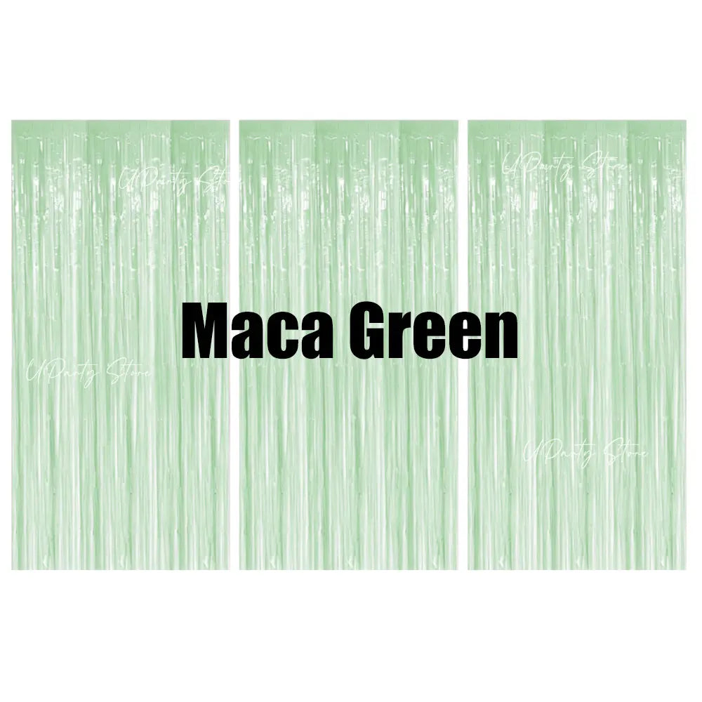 Three vertical panels of light green metallic fringe curtains used as a party backdrop decor.