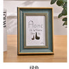 A framed print featuring the text Home is Where the is, displayed in a teal-green wooden frame.