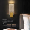 Modern bubble crystal LED wall sconces mounted on a dark wall above a bed.