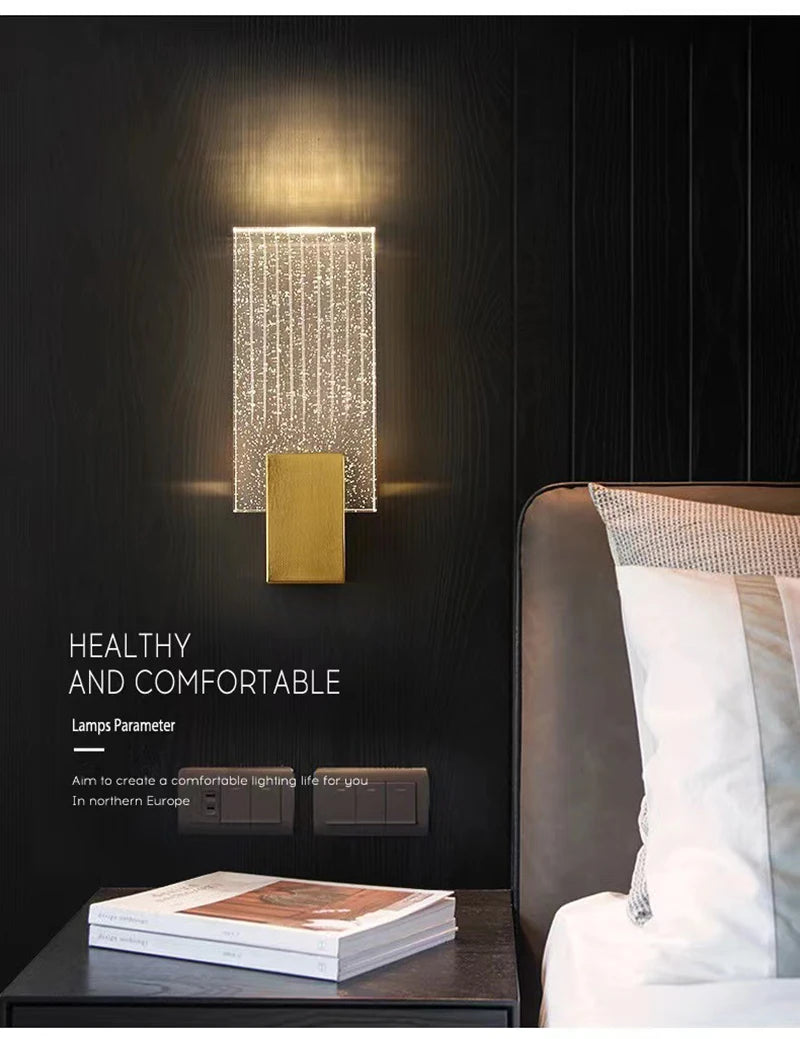 Modern bubble crystal LED wall sconces mounted on a dark wall above a bed.