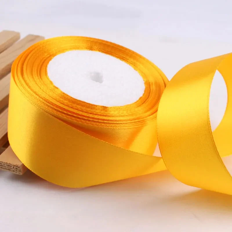 Roll of gold yellow satin ribbon with white filling for crafts and gift wrapping