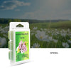 A clear plastic package of scented wax melts labeled Spring, set against a blurred background of a spring field.