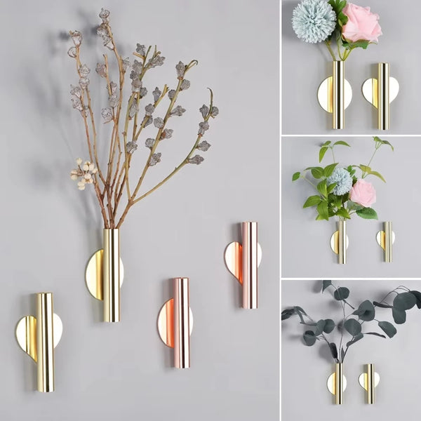 Modern wall-mounted flower vase featuring various dried branches and fresh flowers in gold and rose tones.