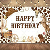 A decorative backdrop featuring a cow print pattern, rustic elements like a cowboy hat, skull, and wooden barrel, for a birth