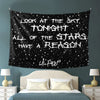 A black tapestry wall hanging featuring white text that reads Look at the sky tonight all of the stars have a reason.