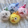 A collection of colorful plush doll charms featuring various animals and whimsical designs.