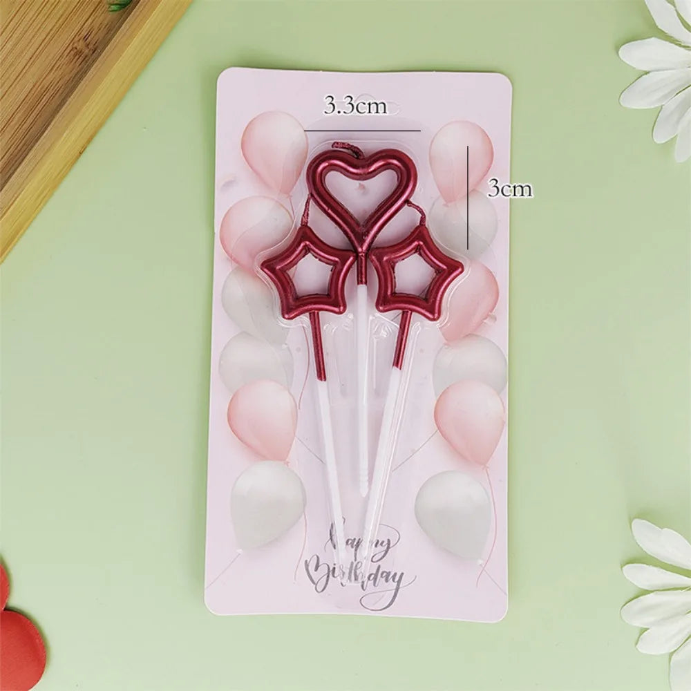 A pink card with three red heart-shaped candles and surrounding pink and white balloons for a birthday celebration.