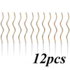 Twelve gold spiral birthday cake candles with star toppers arranged in a row.