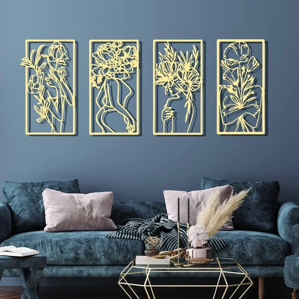A set of four gold line art metal wall decor pieces featuring abstract female silhouettes on a dark blue wall.