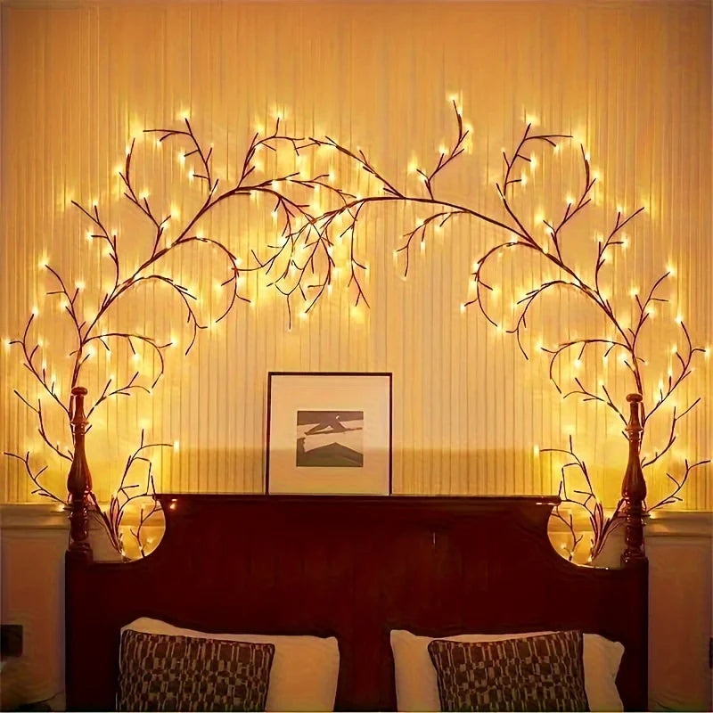 Flexible willow branch LED lights illuminating a framed picture above a dark wooden cabinet.