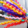 A large, colorful spiral twist latex balloon decoration featuring yellow, purple, pink, and orange balloons.