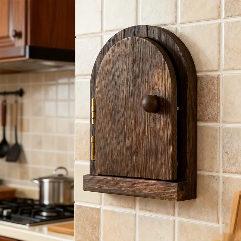 A dark brown wooden decorative outlet cover mounted on a beige tiled wall.