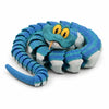 A blue and green articulated snake desk toy with yellow eyes coiled in a circular shape.