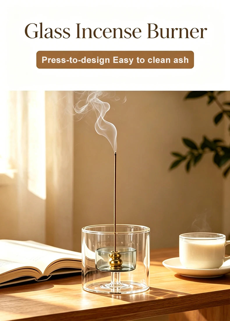 A glass incense burner with a long metal stick is shown emitting smoke on a wooden table.