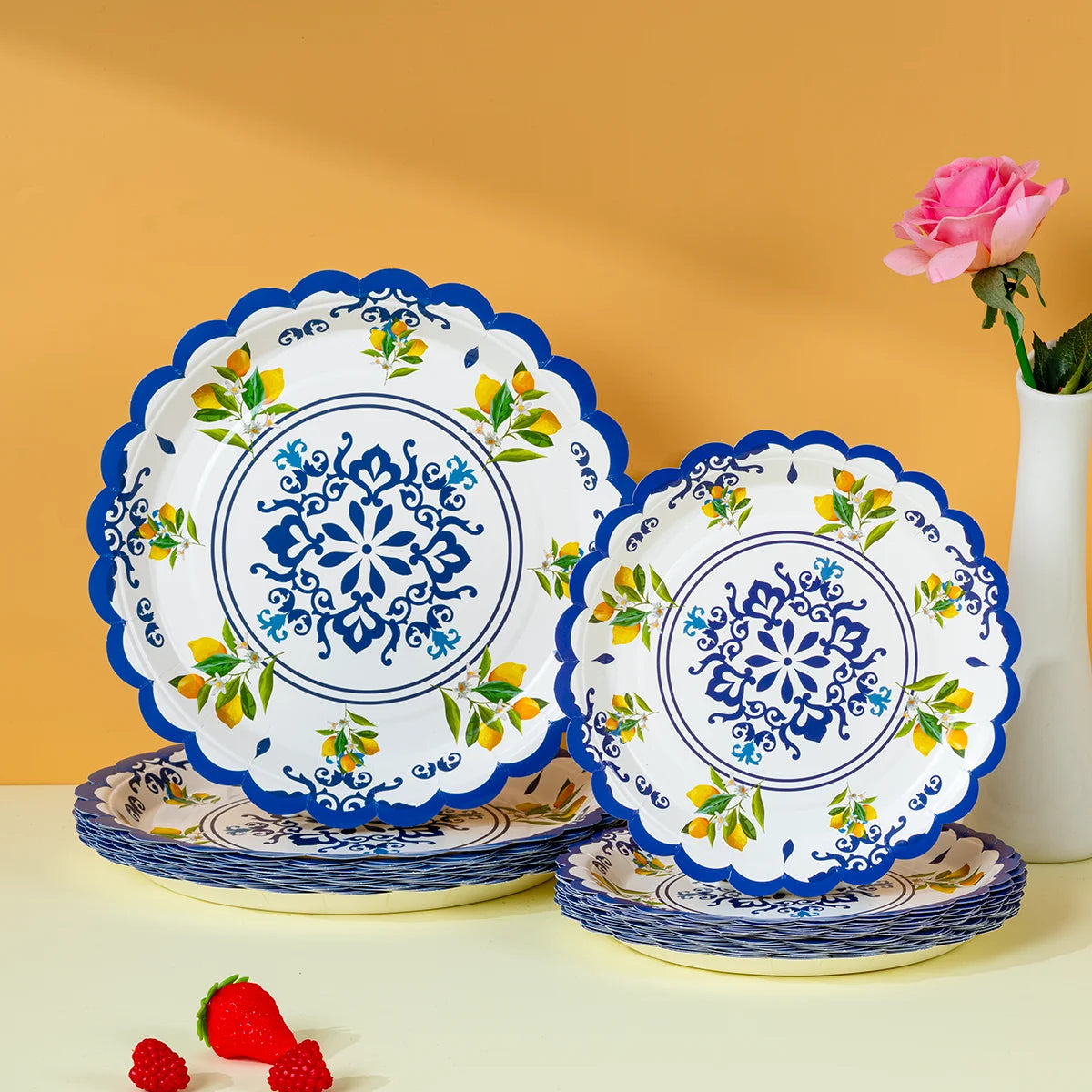A stack of blue and white floral disposable paper plates with yellow accents on a light surface.