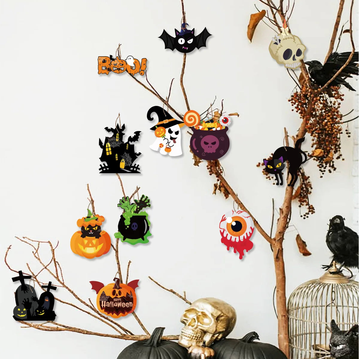 A collection of Halloween hanging ornaments featuring ghosts, pumpkins, and skulls on bare branches.
