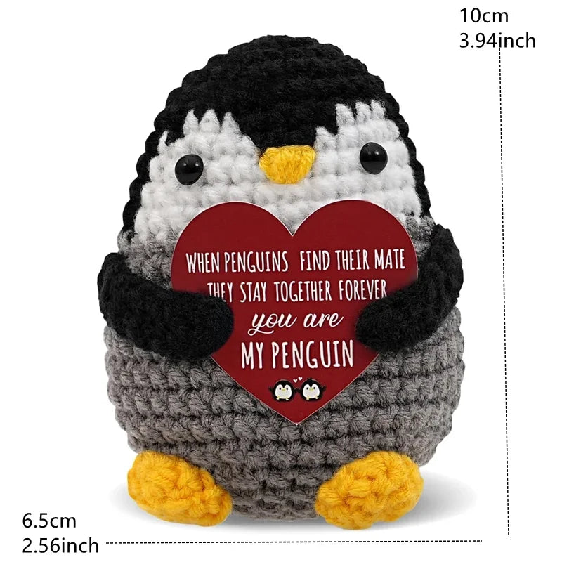 A handcrafted crochet penguin doll with a red heart tag that reads When penguins find their mate they stay together forever.