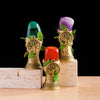Three natural crystal trees of life chimes in shades of green, purple, and red displayed on light blocks.