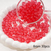A clear glass dropper shows a pile of bright red round spacer beads for jewelry making